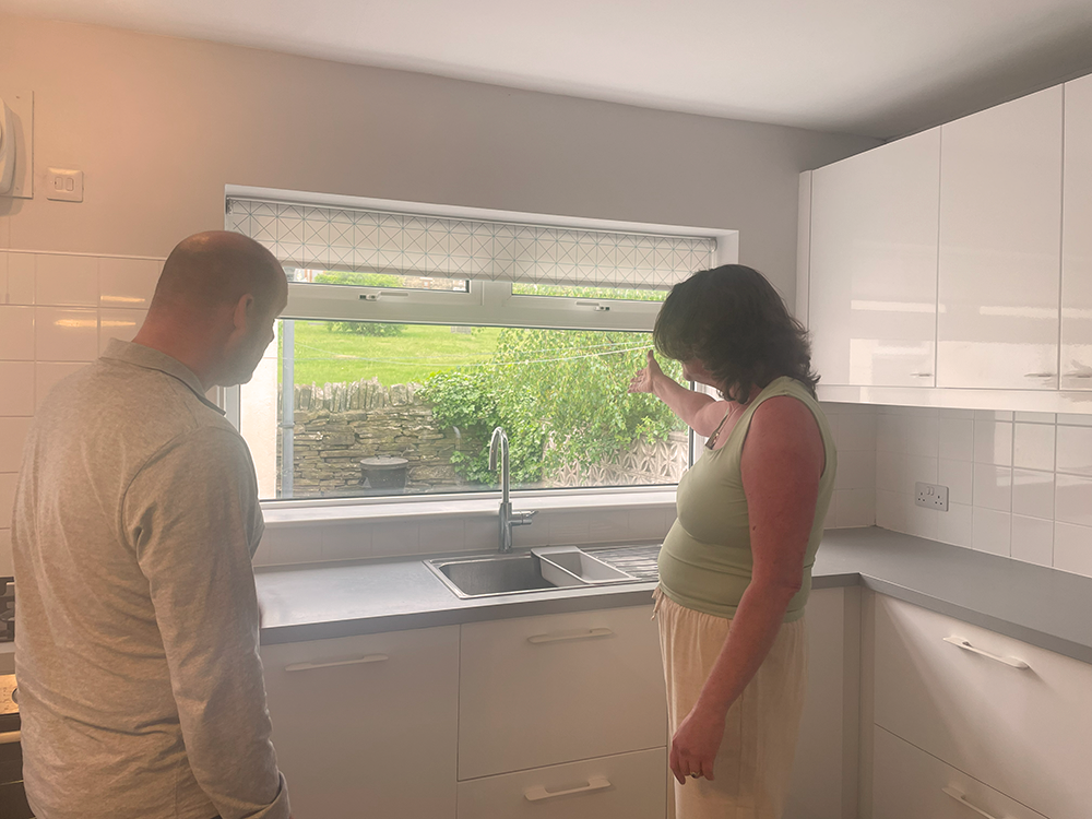 Tenant being shown around a Patchett Homes property with a new kitchen on a sunny day. 