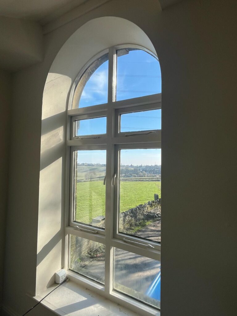 Arched window letting in natural light on a sunny day. 